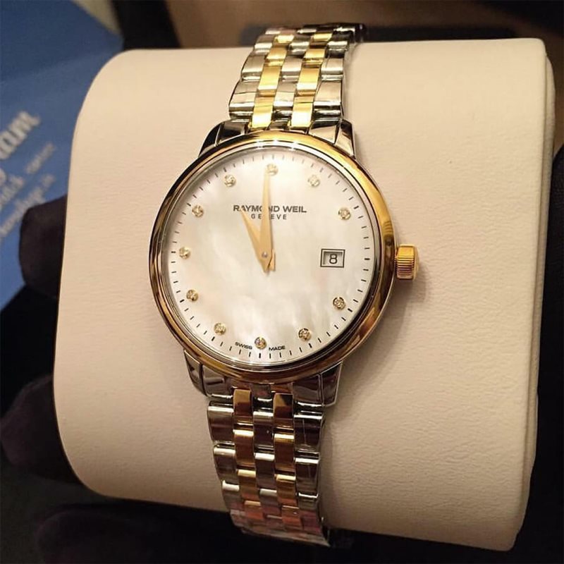 5988-STP-97081 שעון יוקרה לנשים של ריימונד ווייל מסדרת טוקטה | שעון משולב זהב בלוח פנינה משובץ 11 יהלומים ותאריכון | שנתיים אחריות | Ladies Two-Tone Gold 11 Diamond Quartz Watch - Toccata