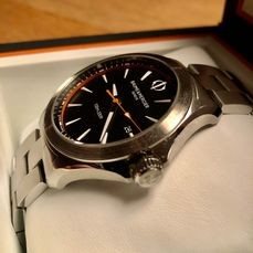 10412 שעון יוקרה של באום מרסייה לגברים | דגם בלוח שחור וכתום | מחוגים ואינדקס זוהרים בחושך | כולל שנתיים אחריות | מלאי מוגבל | Baume & Mercier Clifton Club Quartz Black Dial Stainless Steel 10412