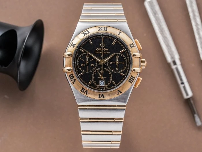 1242.50.00 שעון אומגה קונסטליישן כרונוגרף לגברים יד 2 | שעון שמור משולב זהב 18Kעם ברים מלאים | לוח שחור מיוחד | כולל אחריות | Omega Constellation Double Eagle Chronograph 39mm 1242.50.00 18K GOLD