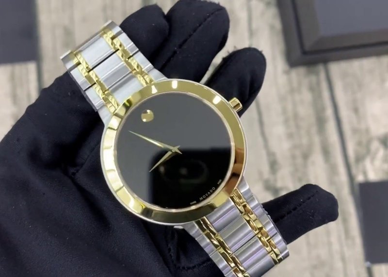 0607278 שעון מובאדו אלגנטי קלאסי לגבר | דגם משולב זהב לוח שחור נקי ומיוחד | שעון שווצרי יוקרתי דק | שנתיים אחריות | Movado Stiri Two-Tone Mens Watch 0607278